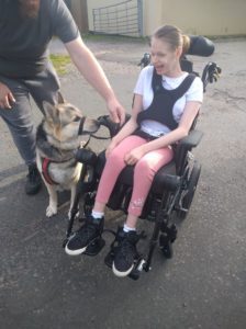 Grace in her wheelchair with her dog