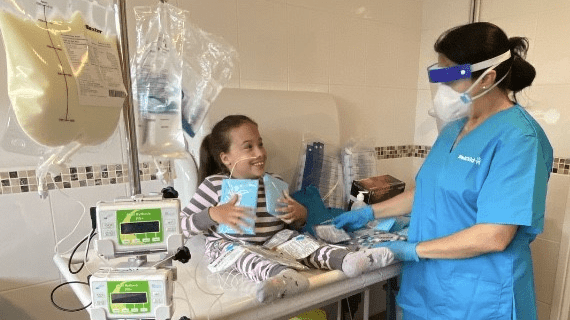 WellChild Child with her carer in full PPE