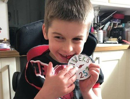 Oliver holding the Step Up medal he designed