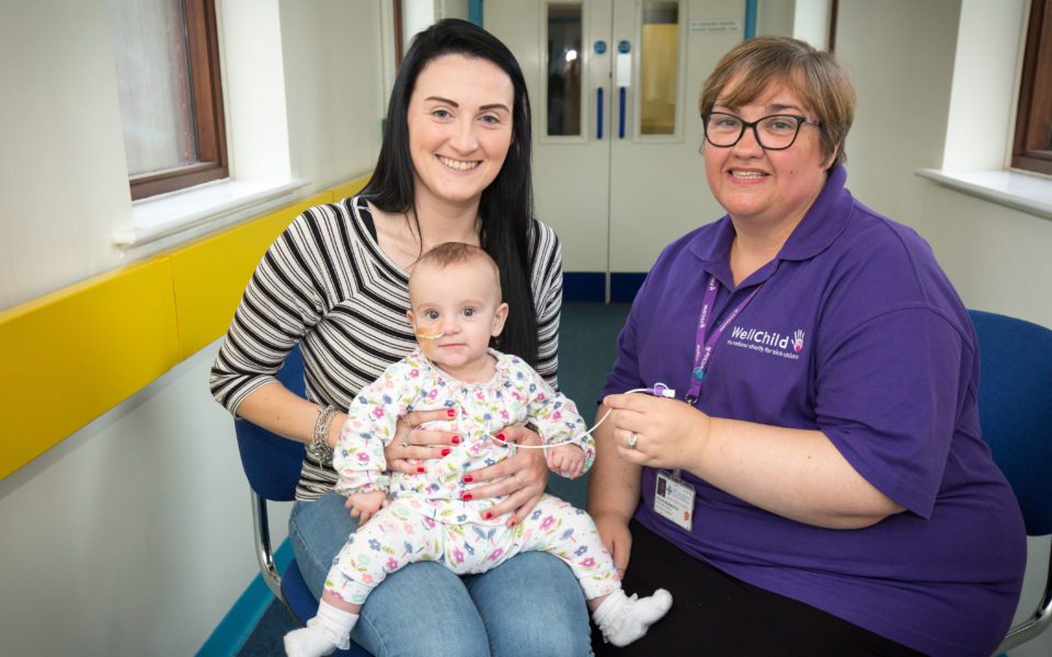 Phoebe and her mum sat with WellChild Nurse Esther