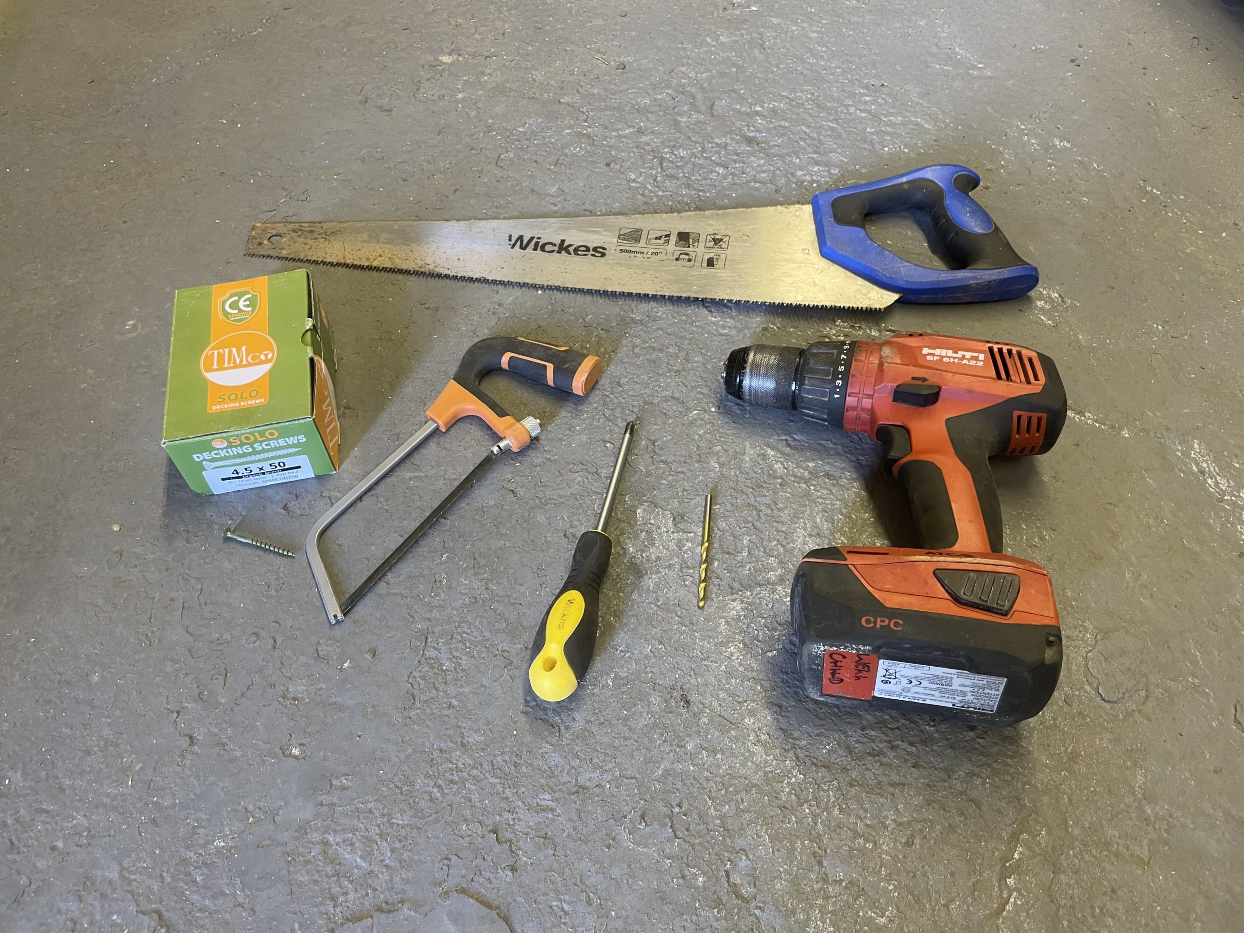 Selection of tools needed for a DIY project laid out on the floor