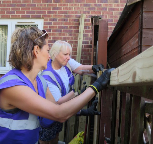 Volunteers fixing a garden fence