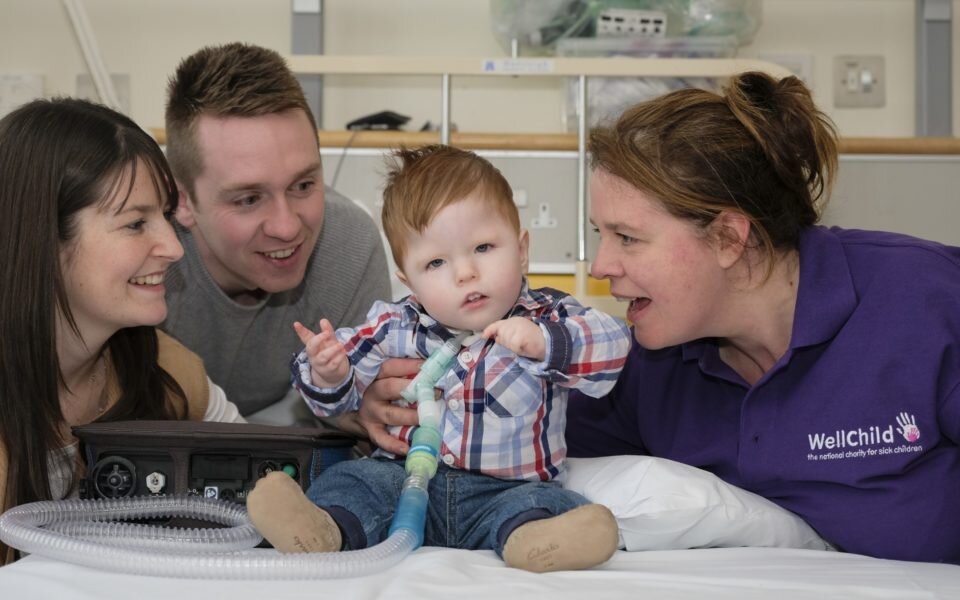 Rogan with his mum, dad and WellChild Nurse Linda