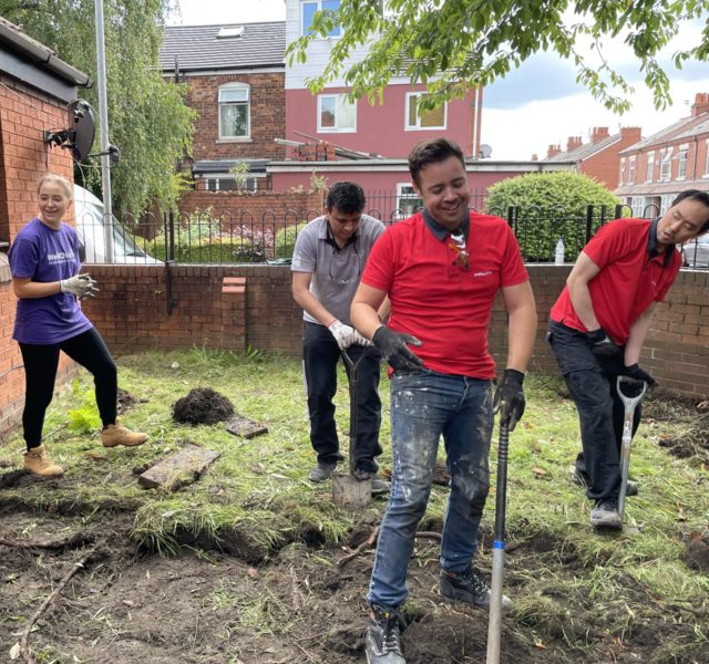 Helping Hands volunteers digging with spades