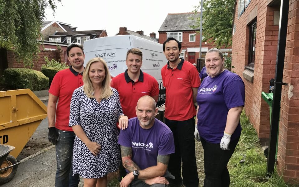 Helping hands volunteers stood with WellChild team after working on a garden transformation.