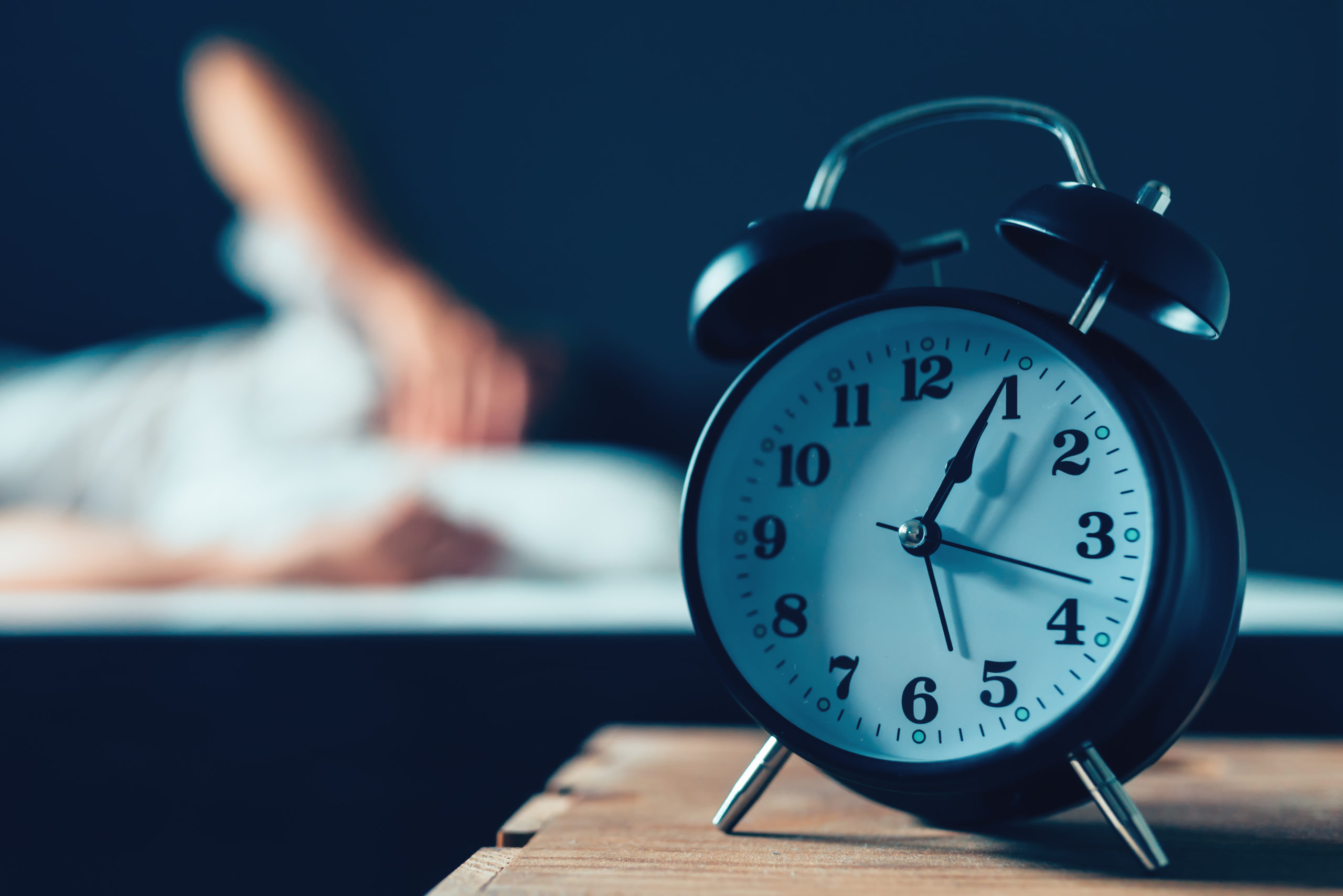 alarm clock and someone struggling to sleep