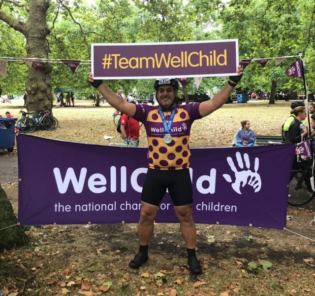 WellChild RideLondon cyclist with the WellChild banner