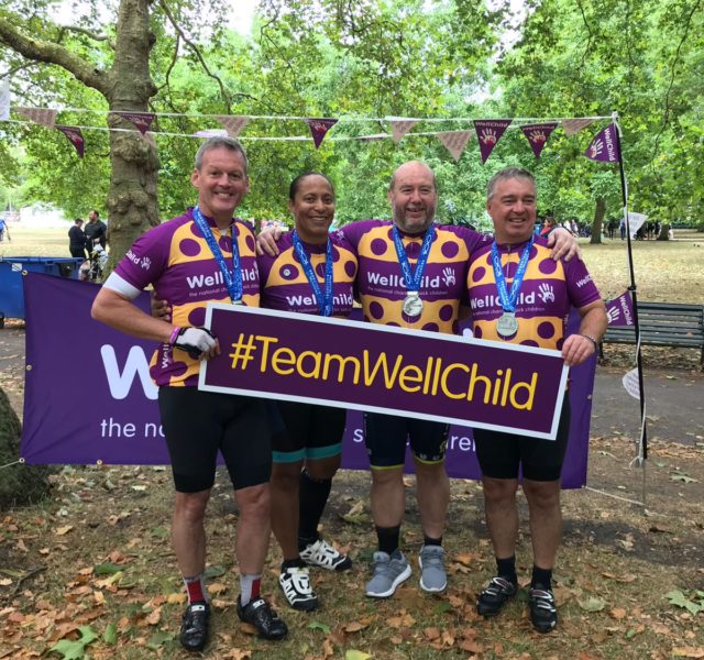 Four WellChild RideLondon cyclists with the WellChild banner