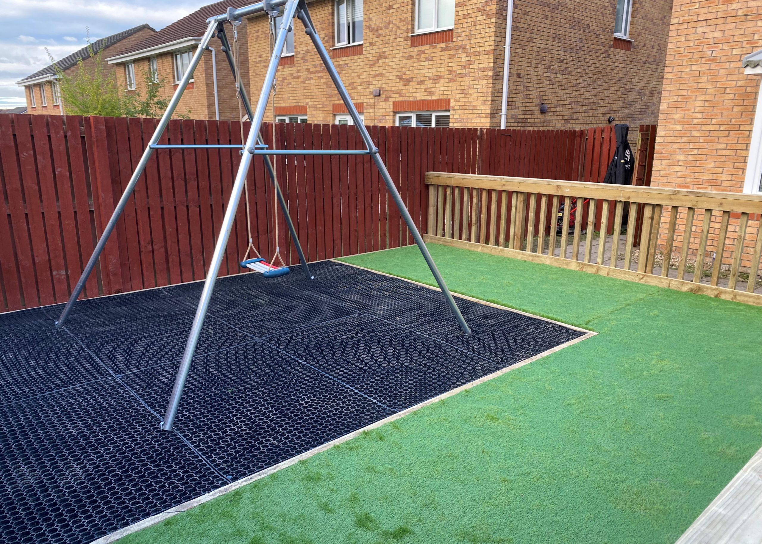 Garden with a swing over rubber matting