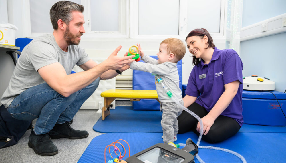 Benjamin and his dad with WellChild Nurse Alex